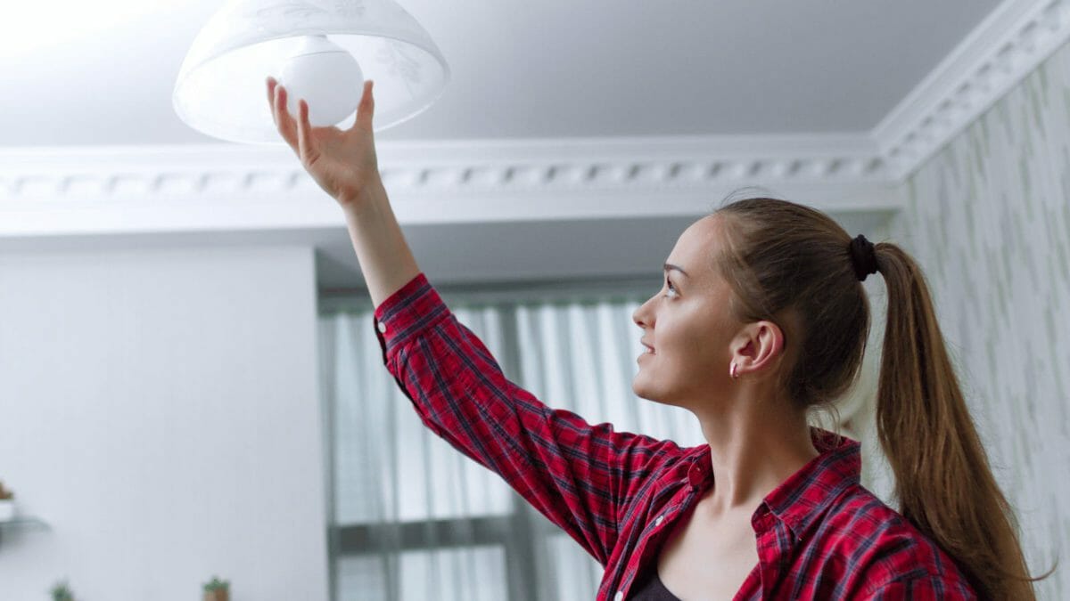woman changing a light bulb