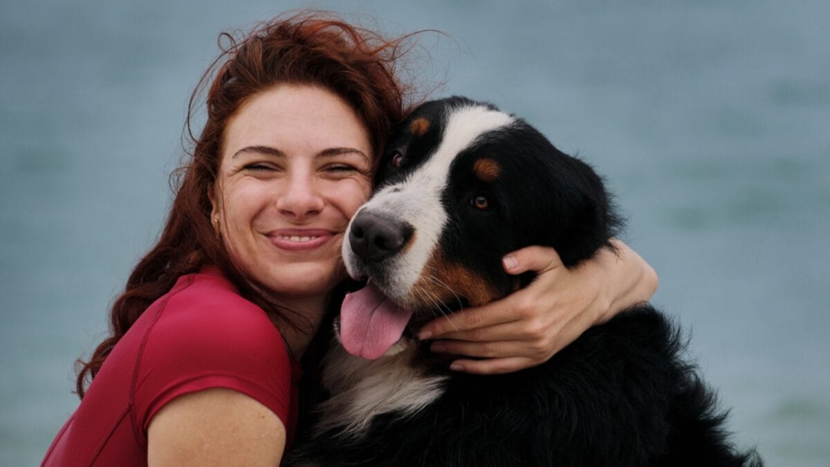 Does Your Dog Really Trust You... 15 Signs That Say Yes - woman hugging bernese dog ss2006378123