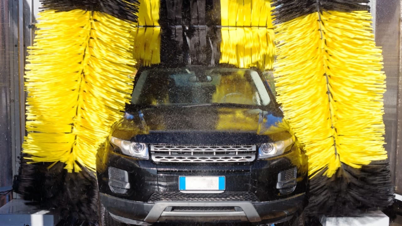 Automatic Car Washes May Be Costing You More Than You Think - Black car going through car wash dp45037755