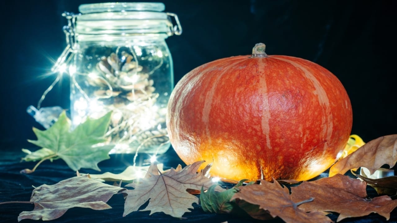 Cozy Fireplace Vibes: 25 Fall Mantel Decor Ideas for 2024 - pumpkin glass jar with pinecone and fallen leaves ss2213984907