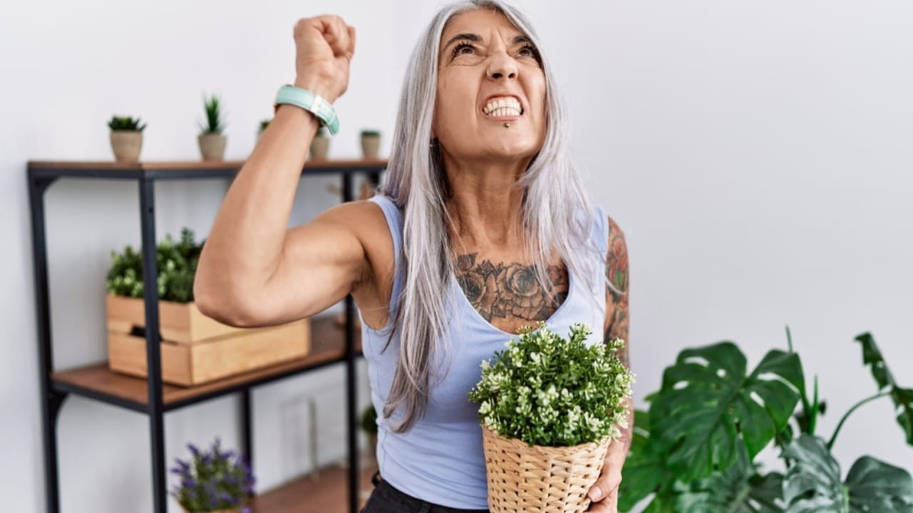 Beware of These 15 Plants—They'll Quickly Become Your Worst Enemies - woman holding green plant ss2221482603