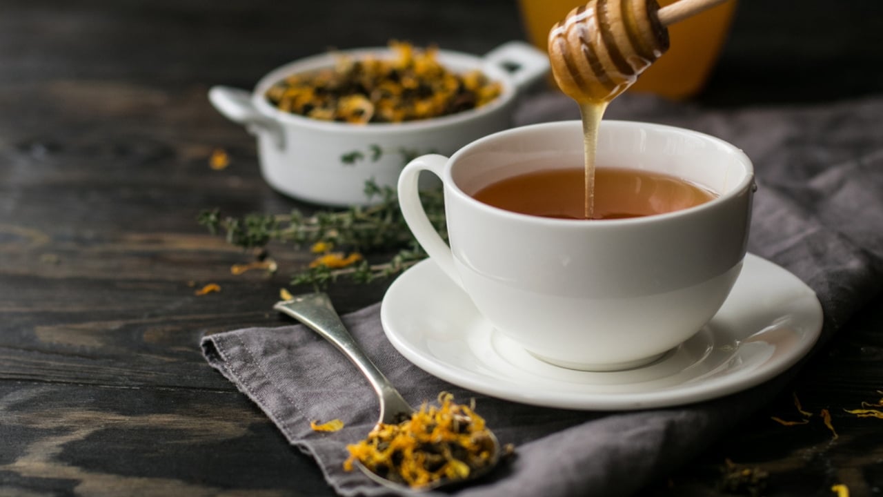 15 Everyday Problems Honey Can Solve Naturally - Cup with herbal tea and honey ss535363120 dpdgm